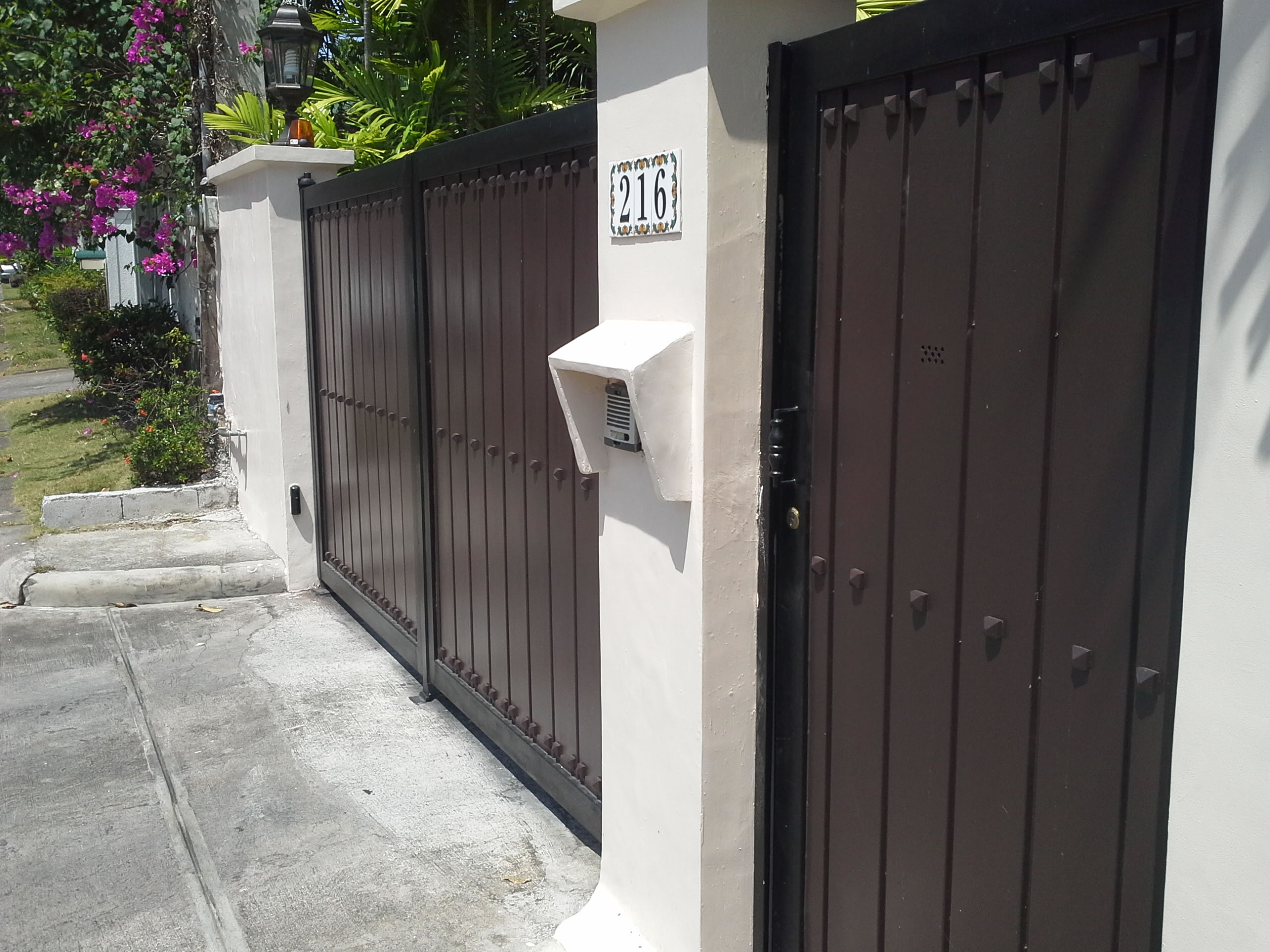 Gate in wood finish and wrought iron frame and studs accent.